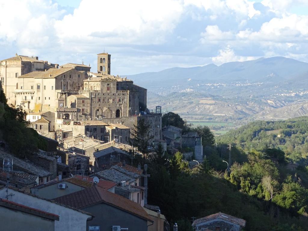 uma cidade numa colina com edifícios e montanhas em La Casa Del Sole em Bomarzo