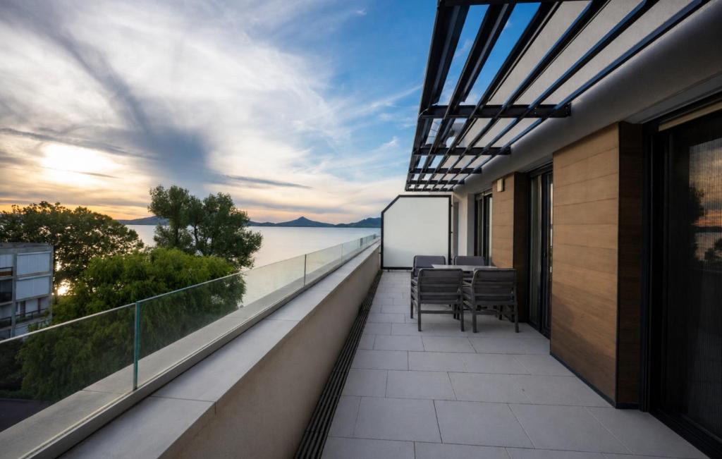a balcony with chairs and a view of the ocean at Lakeview Apartment Fonyód in Fonyód