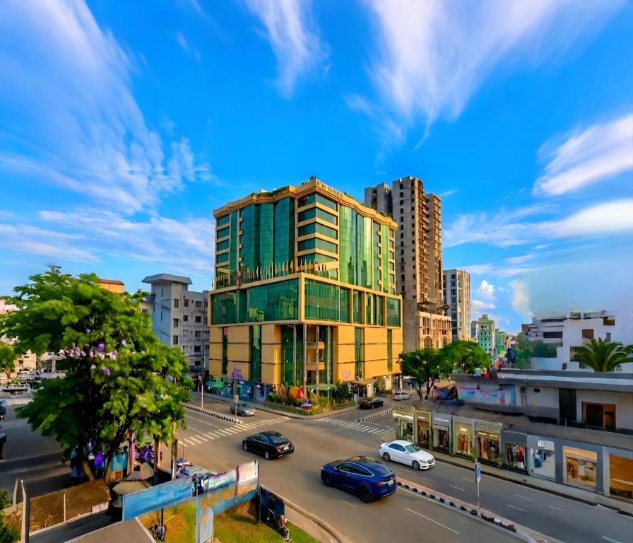 a tall green building in a city with a street at Rose View Hotel Sylhet in Sylhet