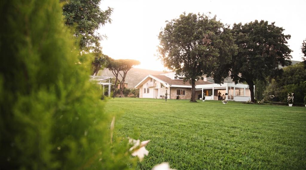 a house in a yard with a green field at Artemide Resort Spa - Private Villa in Lido Di Fondi