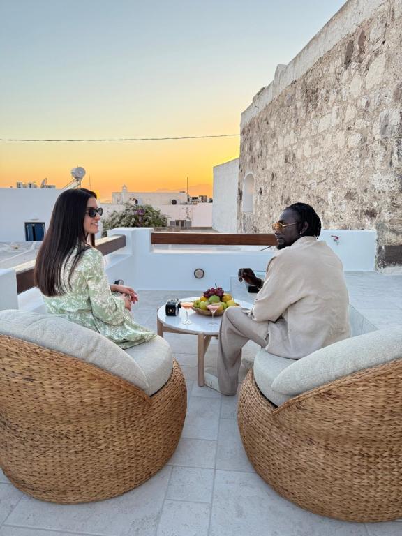 a man and a woman sitting in chairs on a patio at PEA Plaka Authentic Home in Plaka Milou