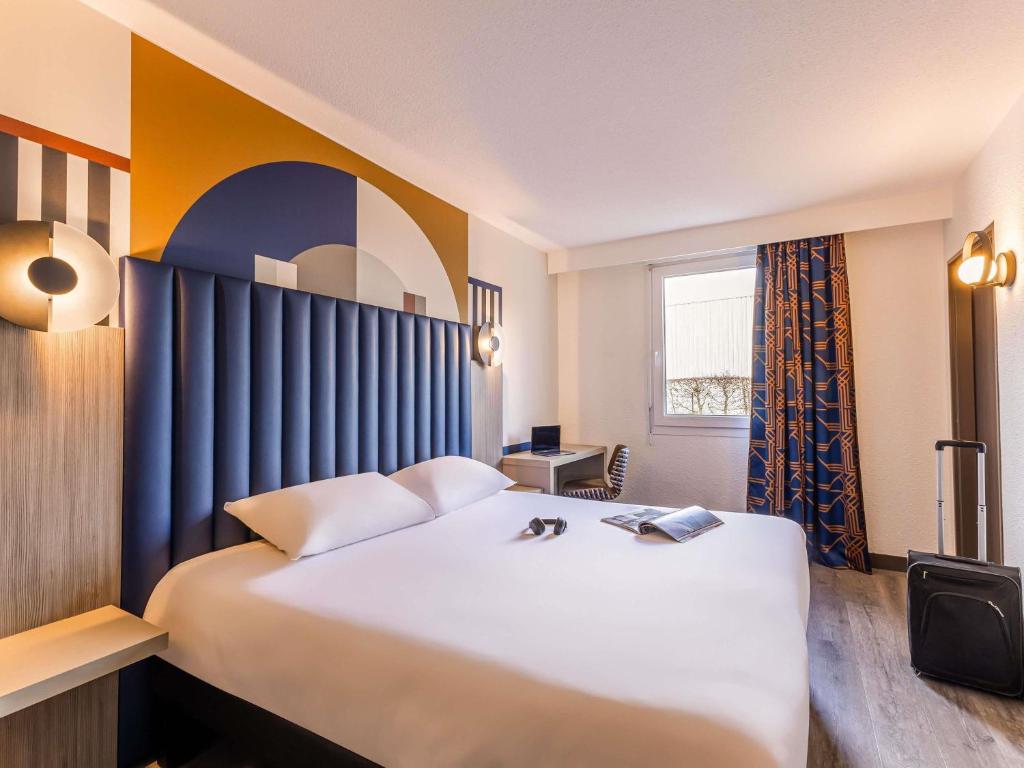 ein Hotelzimmer mit einem großen Bett und einem Fenster in der Unterkunft ibis Styles Saint-Quentin in Saint-Quentin