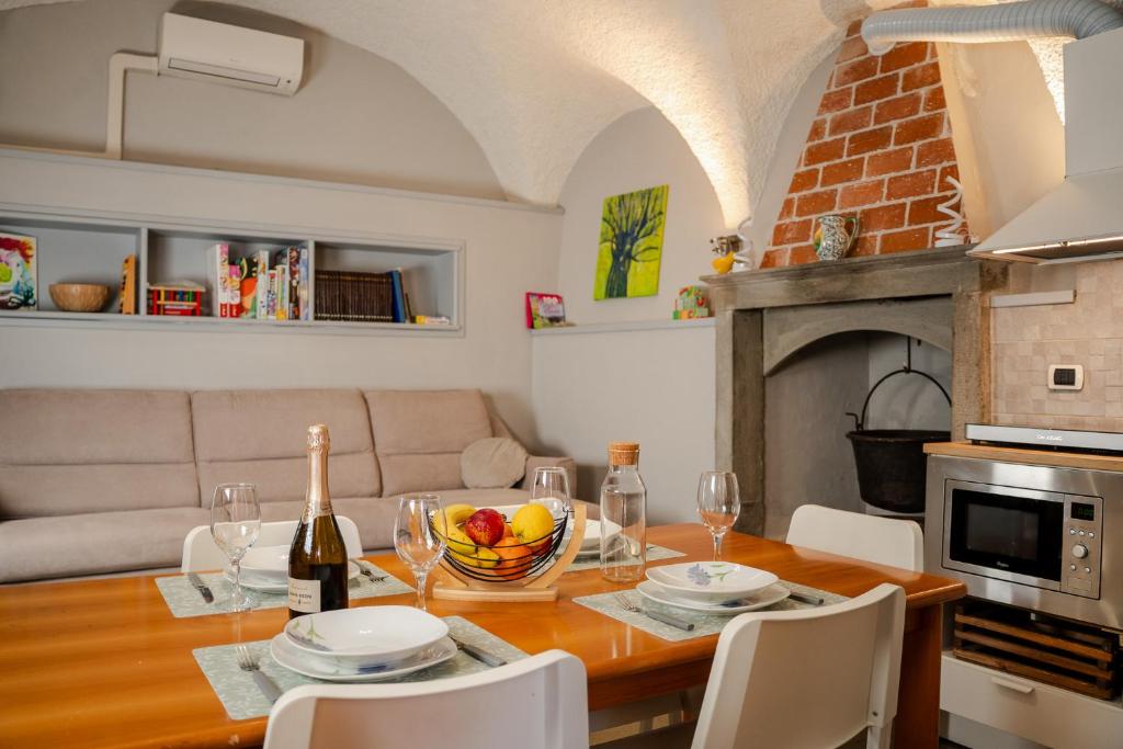 a table with a bowl of fruit and a bottle of wine at La corte del Lago in Sulzano
