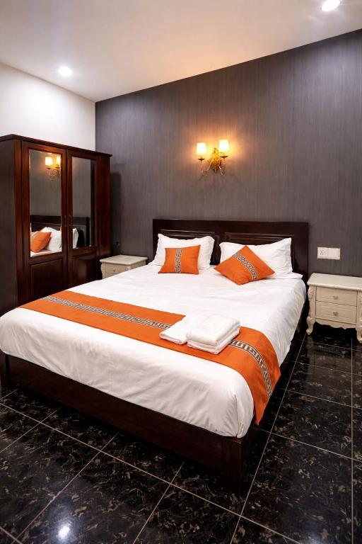 a bedroom with a large bed with orange pillows at YT Hotel & Hostel Vientiane in Vientiane