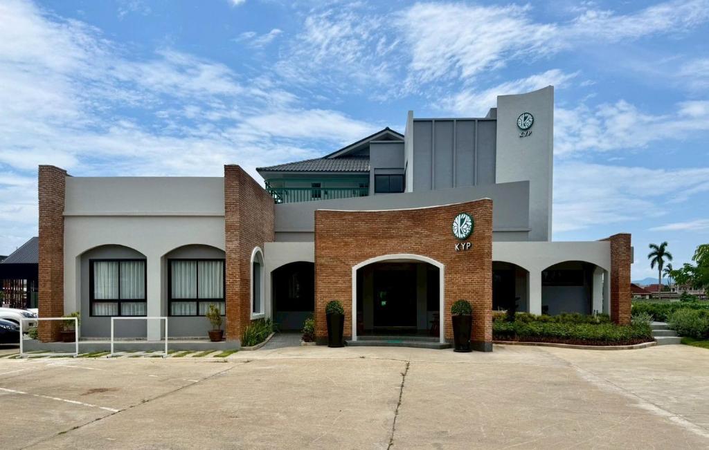 a large brick building with a clock on it at KYP Hotel โรงแรมขุนยูวเพลส in Fang