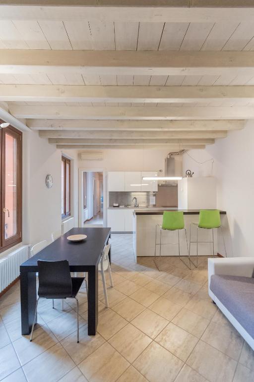 a living room with a black table and green chairs at Trilocale Rua Sovera 85 - F&L Aparment in Brescia