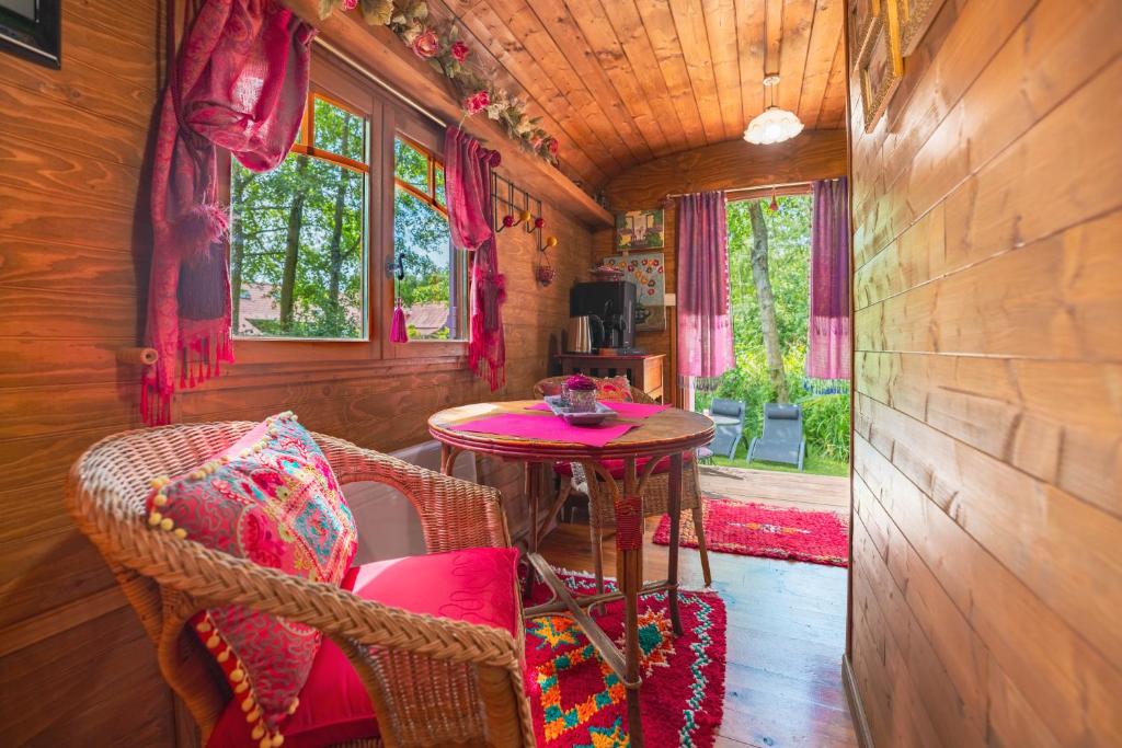 a small room with a table and chairs in a tiny house at Roulotte du Rouard in Camiers