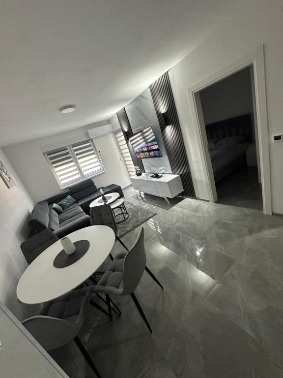a living room with a table and chairs and a couch at Apartment Balkan in Modriča