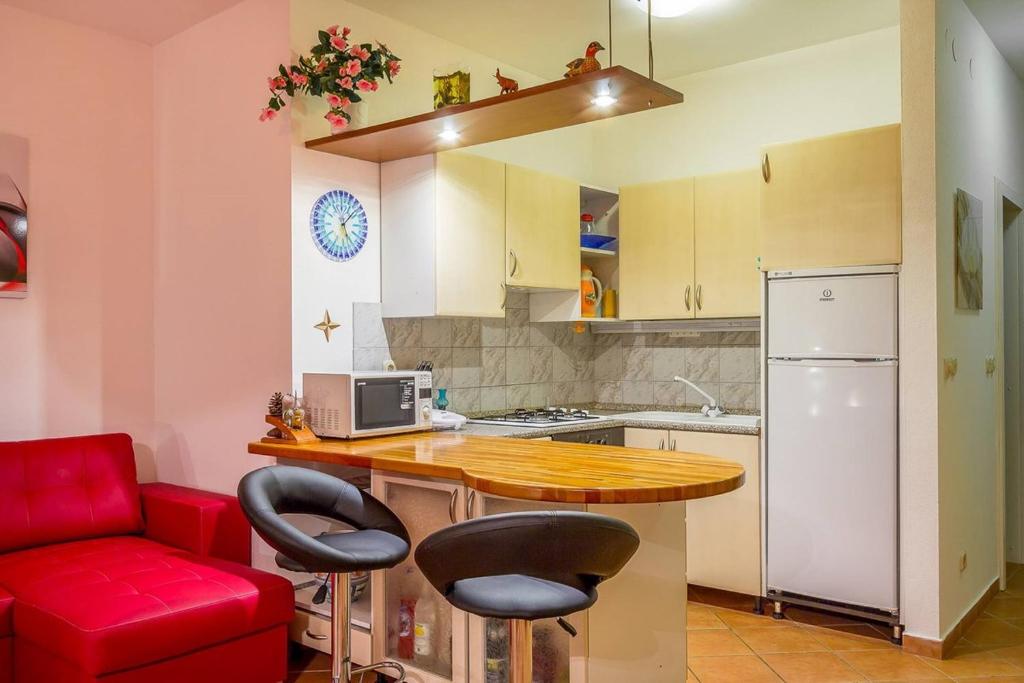 a kitchen with a red couch and a table with chairs at Apartments Villa Ana in Medulin