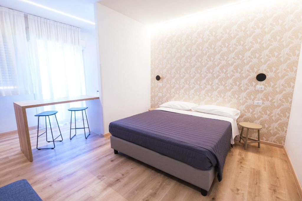 a bedroom with a bed and a table and chairs at Essenza Residence in Cervia