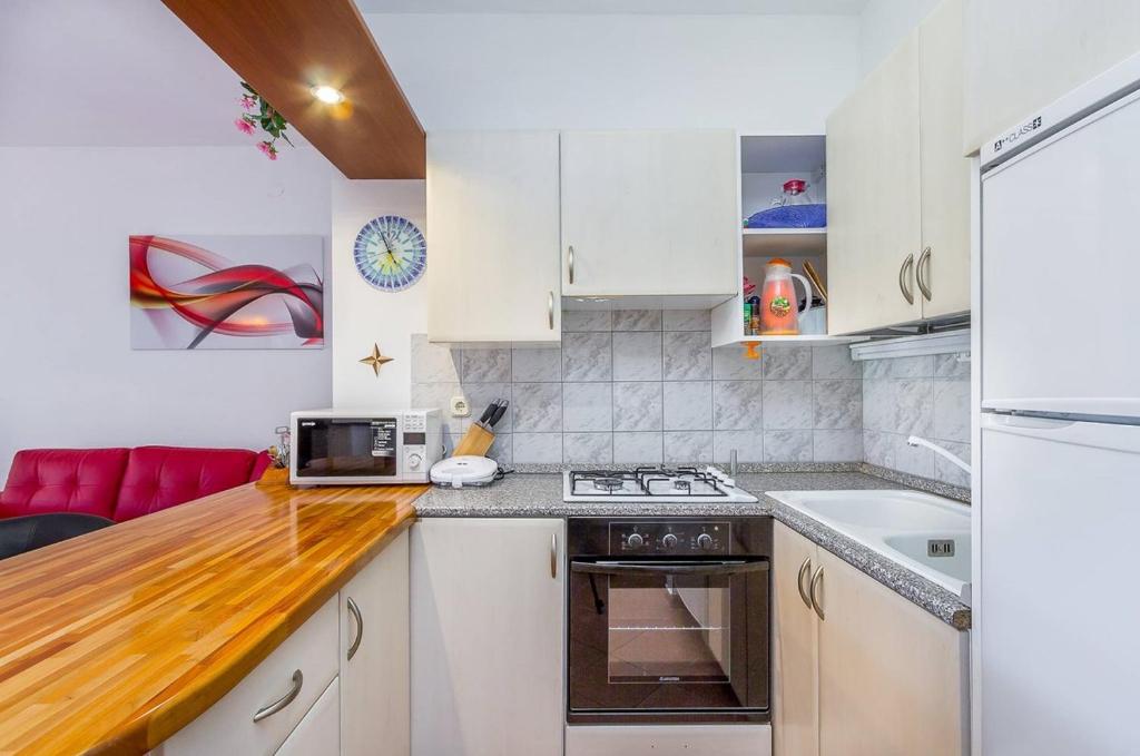 a kitchen with white cabinets and a stove top oven at Apartments Villa Ana in Medulin