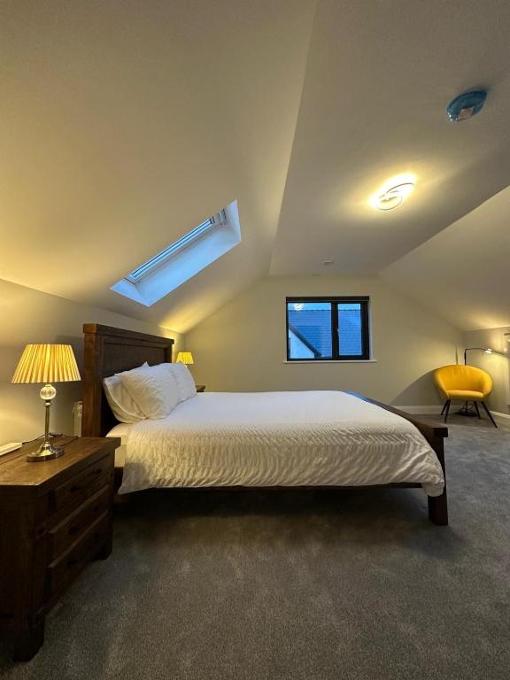 a bedroom with a large bed and a yellow chair at Homestay Wild Atlantic View Binghamstown in Belmullet