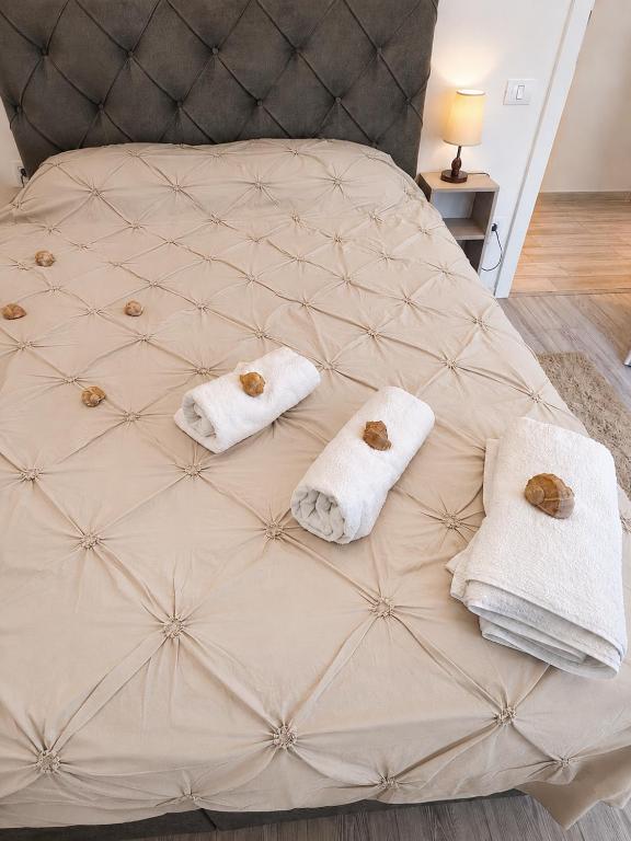 a bed with two towels on top of it at Italy Luxury Apartment front of the sea in Mamaia Sat/Năvodari