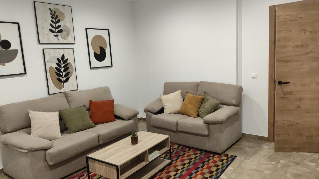 a living room with two couches and a coffee table at Apartamento Zafra Jaime in Zafra