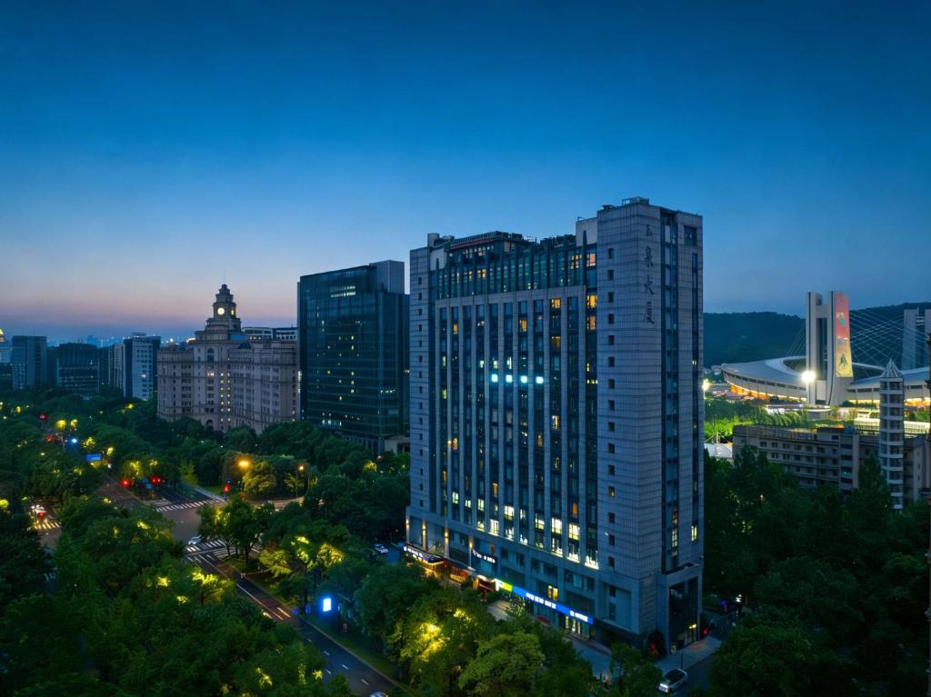 a tall building in a city at night at M Hotel in Hangzhou