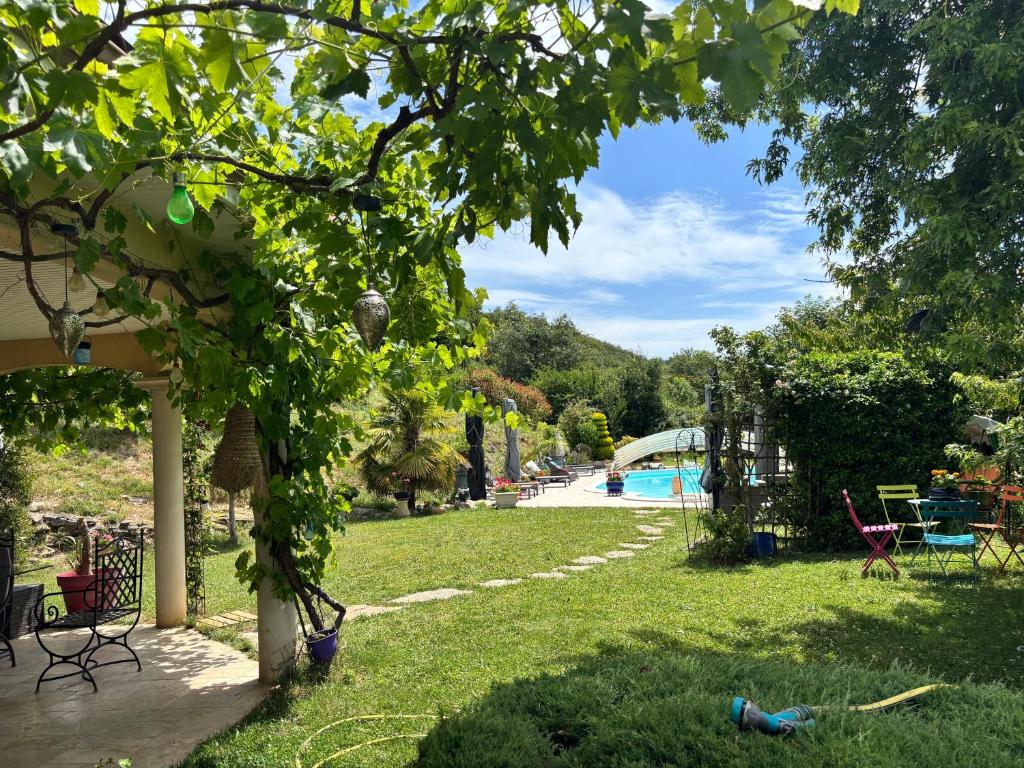a yard with a swimming pool in the background at Maison d'hotes Dolce Vita in Veyssilieu