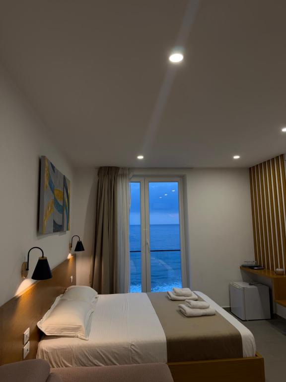 a bedroom with a large bed with a large window at Serenity In in Lezhë