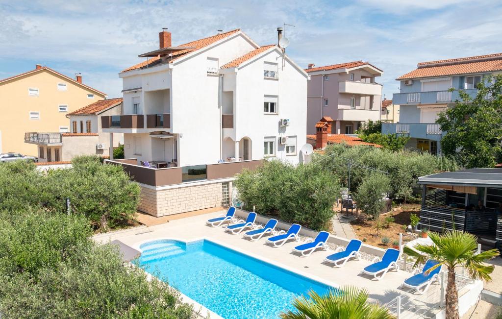 an apartment with a swimming pool and lounge chairs at Olive Dreams in Biograd na Moru