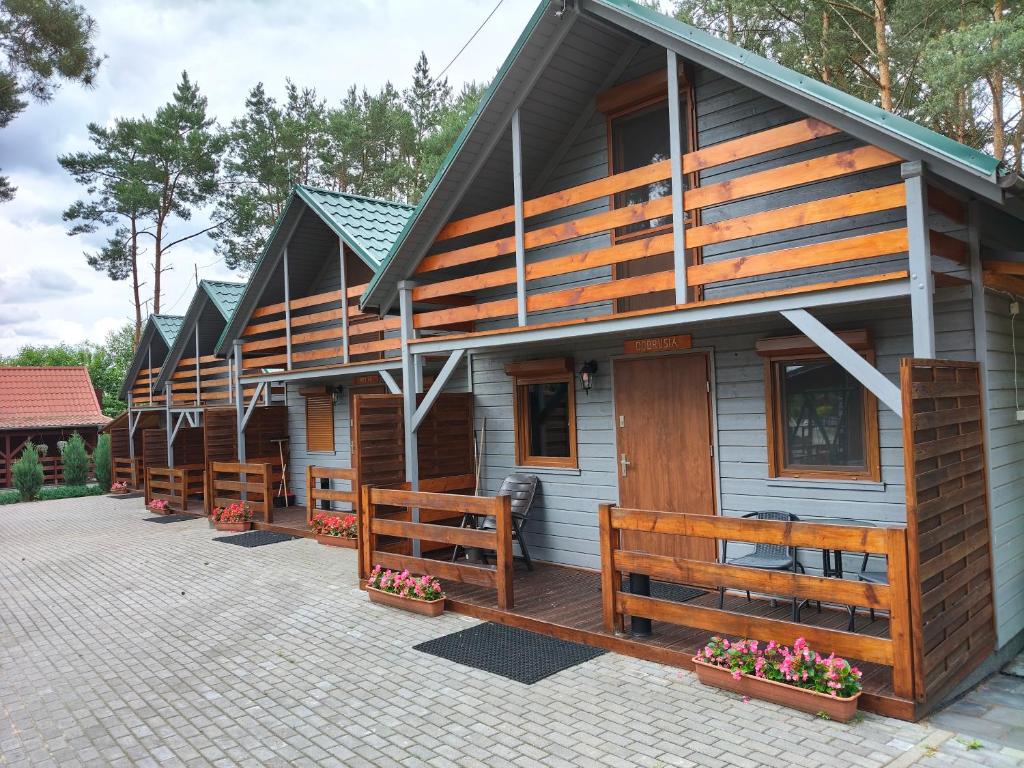 a row of wooden cabins in a row at Domki Piaskowa in Boszkowo-Letnisko
