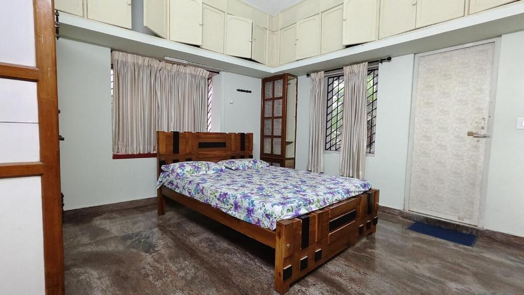 a bedroom with a bed in a room with windows at Kalliyattu Homestay in Palakkad