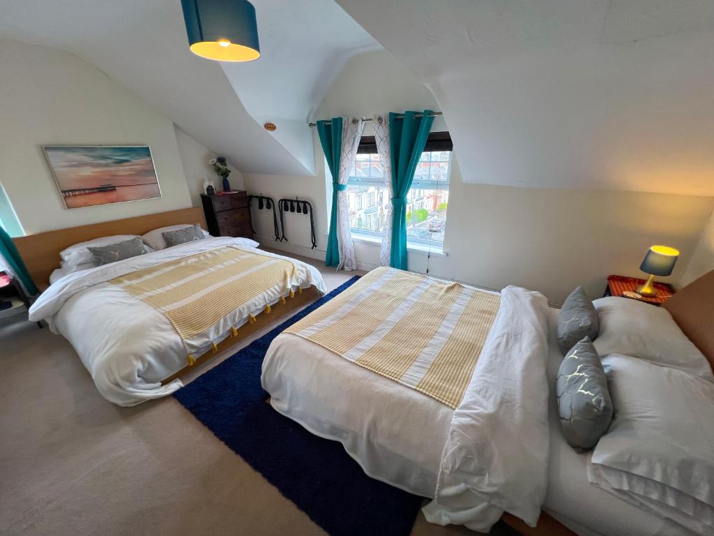 a bedroom with two beds and a blue rug at Chip's House in Pennyburn