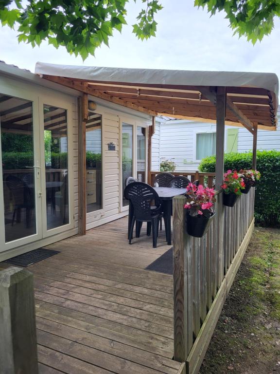a deck with a pergola and a table and chairs at ZEN cocoon in Ivry-la-Bataille