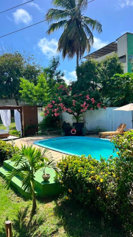 a small swimming pool in a yard with flowers at Casa Folha Tropical in Pipa
