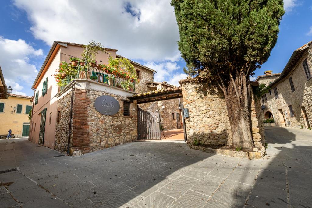 a stone building with a tree in a street at Locanda Casalta in Strove