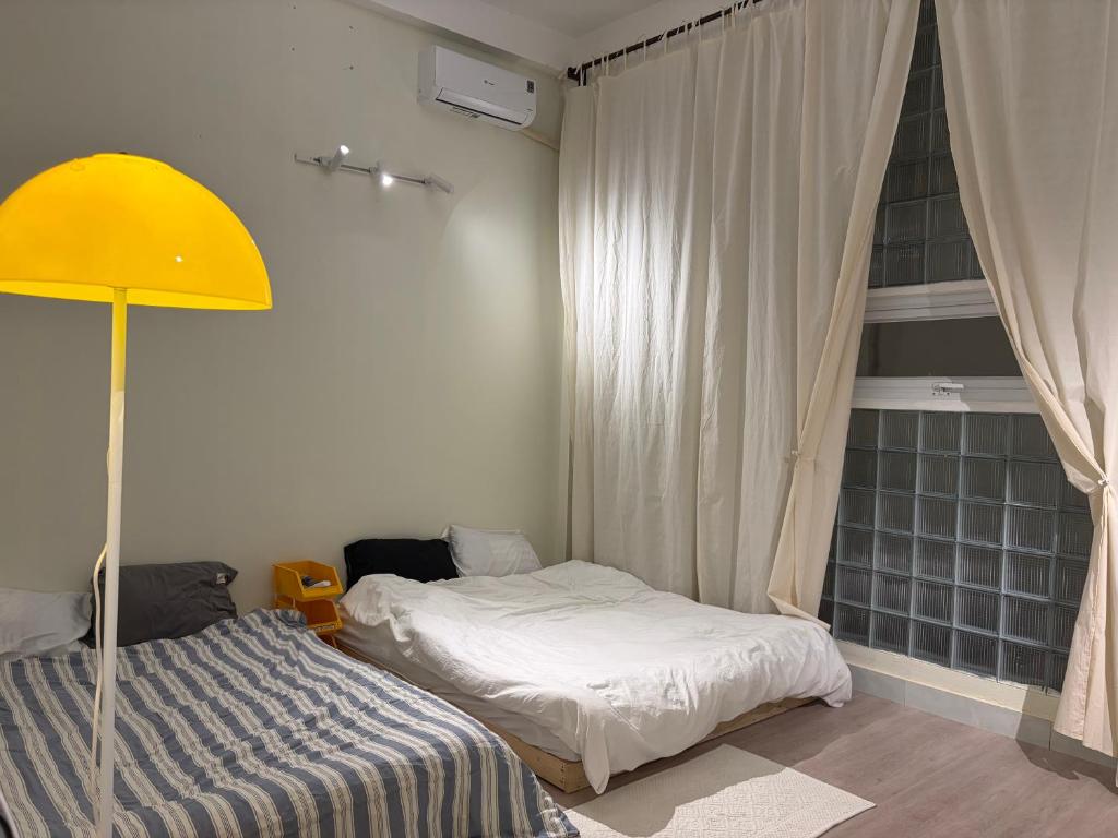 a bedroom with a bed and a yellow lamp at Anhbnb in Danang