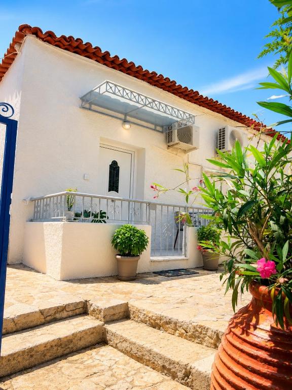 a white house with stairs in front of it at G&D guest house in Ancient Epidauros
