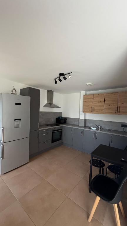 a large kitchen with a table and a refrigerator at Max Wittelsheim in Wittelsheim