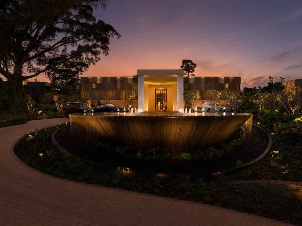 a building with a fountain in front of it at night at Raffles Sentosa Singapore in Singapore