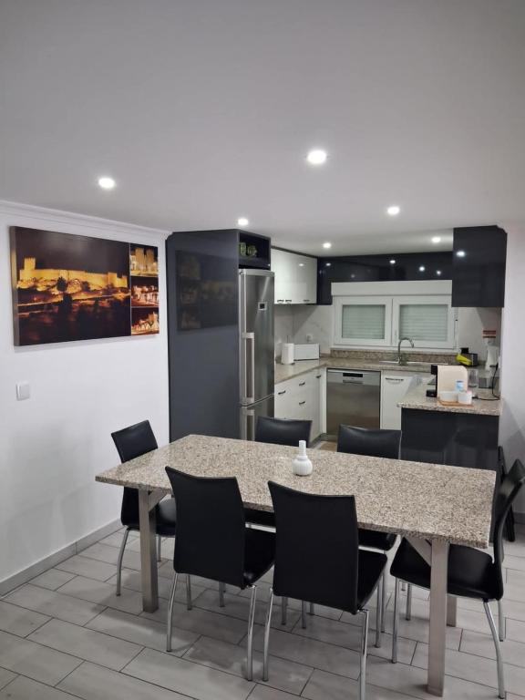 a kitchen with a dining room table and chairs at Casa D'Avó 1 in Trancoso