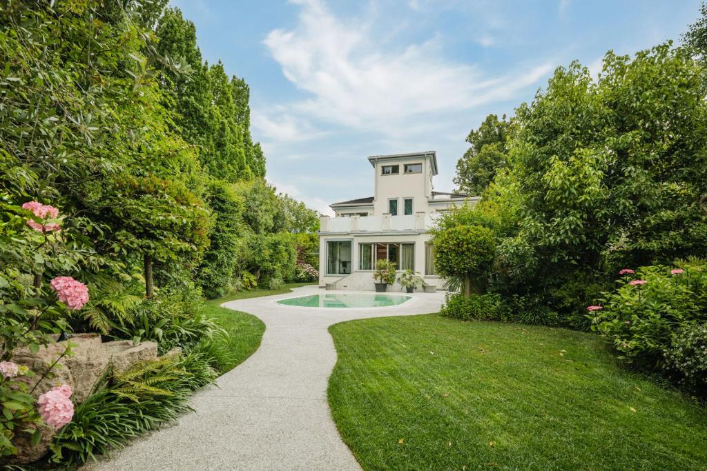 a house with a swimming pool in a garden at Maison Villa Scherlin in Bardolino