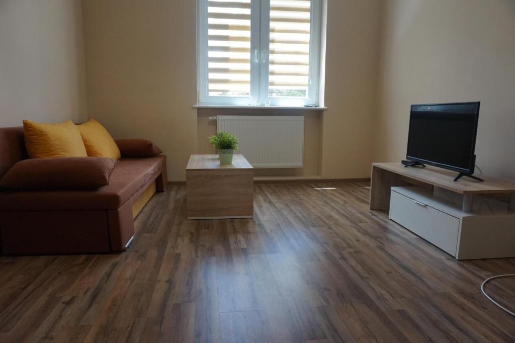 a living room with a couch and a flat screen tv at Baltic Rooms Gdańsk in Skorka