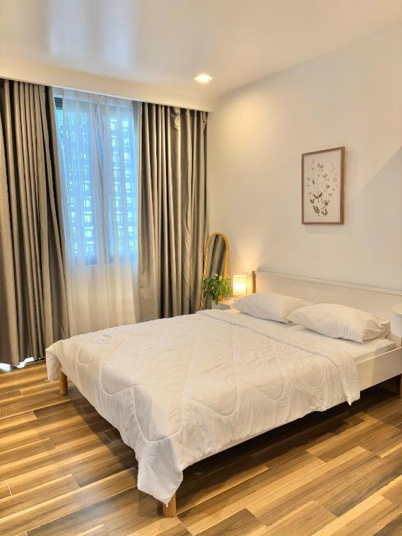 a bedroom with a large white bed in front of a window at NÚP Homestay Huế in Thôn Dương Xuân Hạ