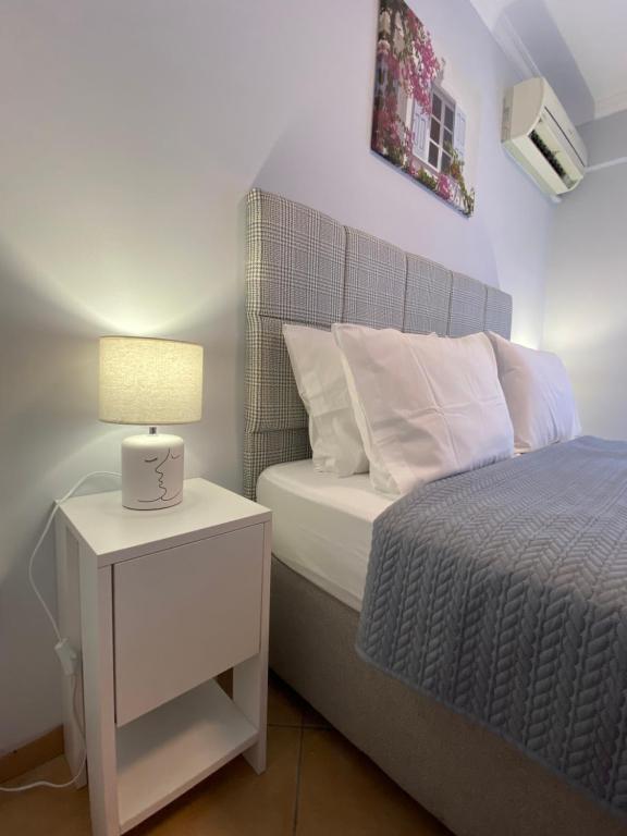 a bedroom with a bed and a table with a lamp at MarSia Apartment in Chios
