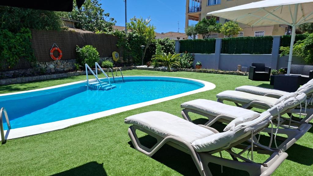 a swimming pool with lounge chairs next to it at Try and Try in Cunit