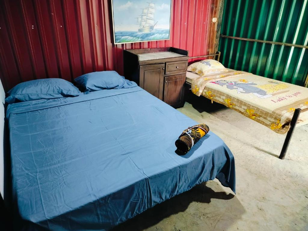 a bedroom with two beds and a dresser in it at Bosque celeste in Rio Celeste
