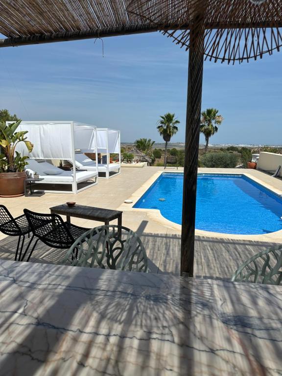 a patio with a table and chairs and a swimming pool at Casa Romeo y Julieta in Castro Marim
