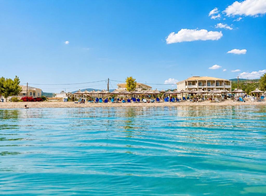 a beach with chairs and people on the sand at Zoom Beach Hotel in Kandia