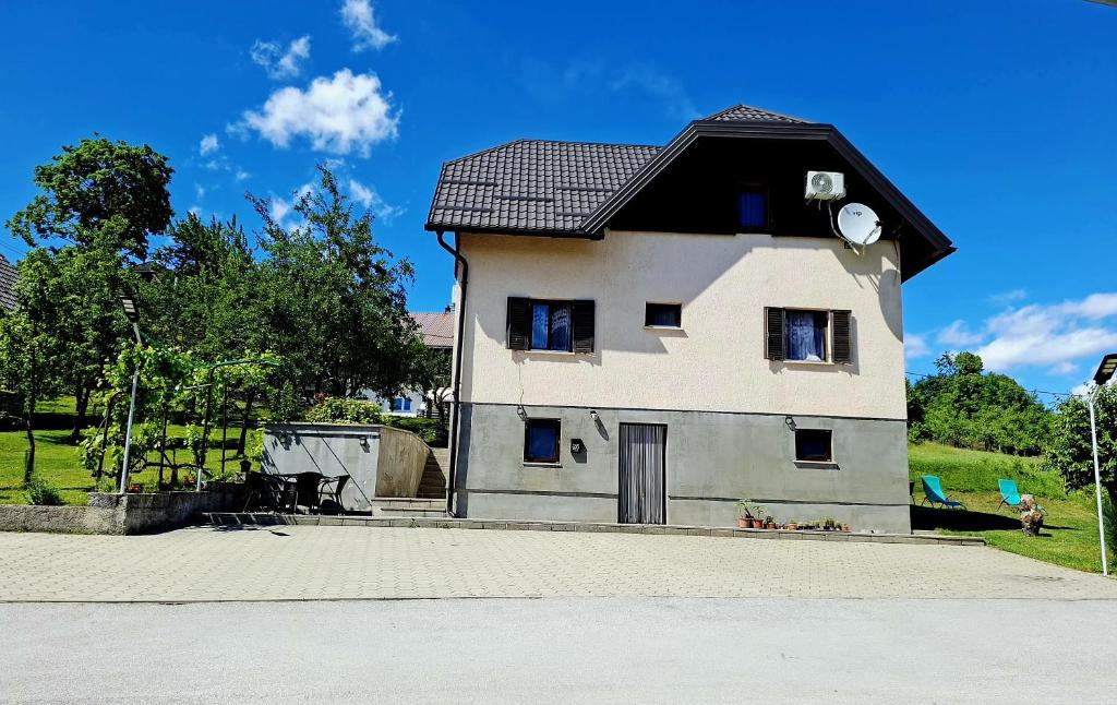 a small white house with a black roof at Guest House Matej & Mateja in Plitvička Jezera
