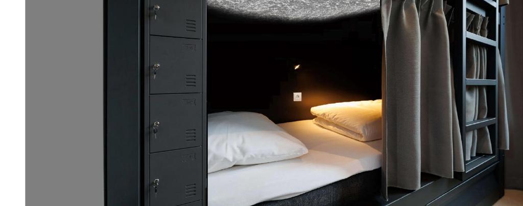 a room with a bed in a black room at Kaunas Center Hostel - Self-Check In in Kaunas