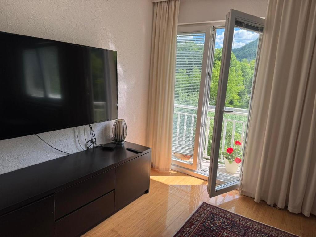 a living room with a flat screen tv and a large window at XXL apartman Free parking in Visoko