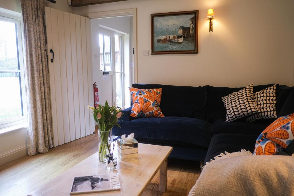 a living room with a blue couch and a coffee table at Heathend in Petworth