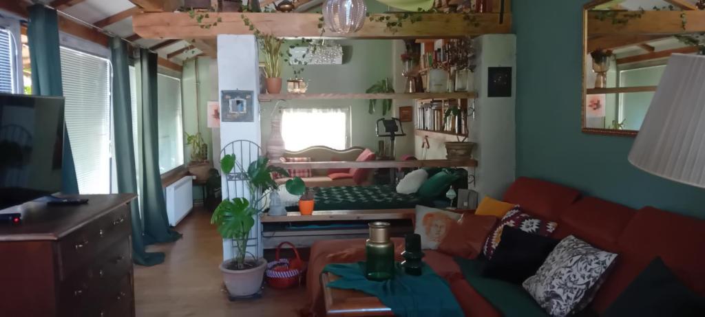 a living room with a red couch and a desk at ROSE ROOM for 4 guests in green Rose resort Ljubljana in Ljubljana