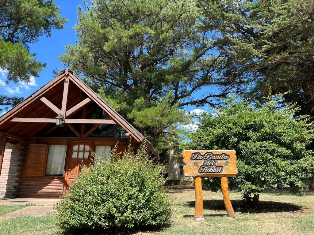 a sign in front of a cabin with a house at La Posada del Hobbit in Villa Ventana