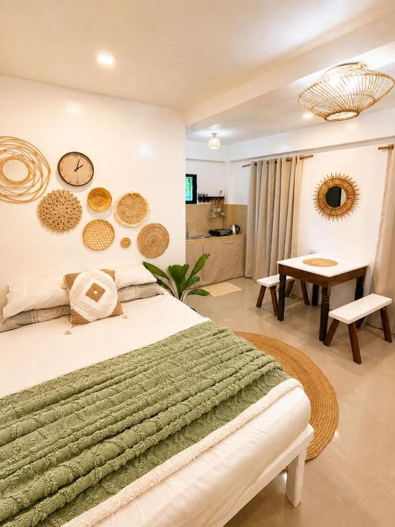 a bedroom with a bed and a table and a clock at A&H Homestay in Catangnan