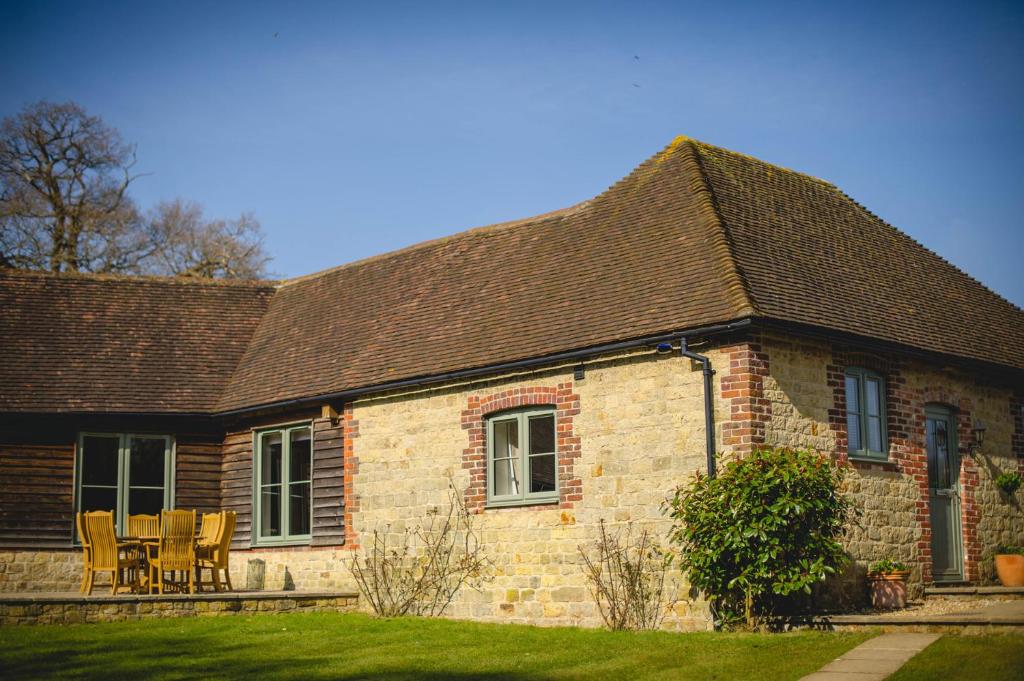a brick house with a table and chairs in front of it at Highfield in Petworth