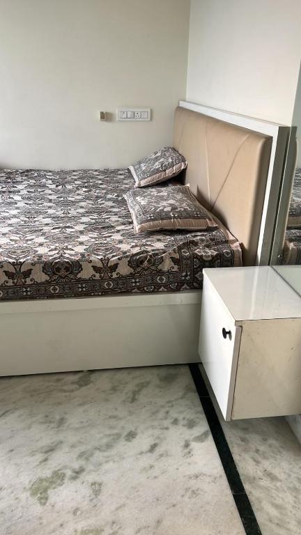 a small bedroom with a bed and a table at PR PREMIUMSUITs in Surūrnagar